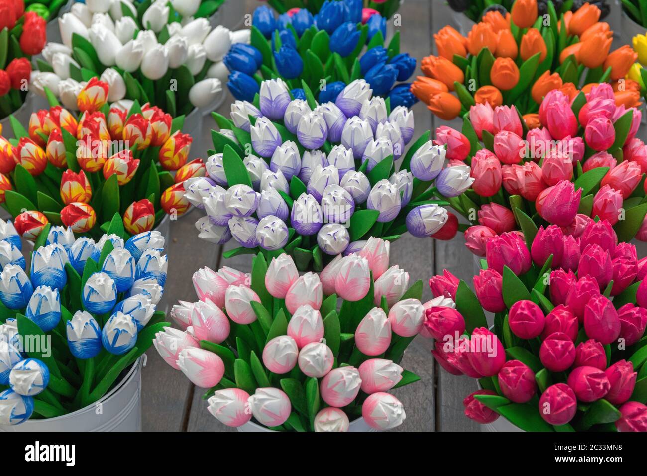 Viele bunte Holz- Tulpen Souvenirs in Eimern Stockfoto