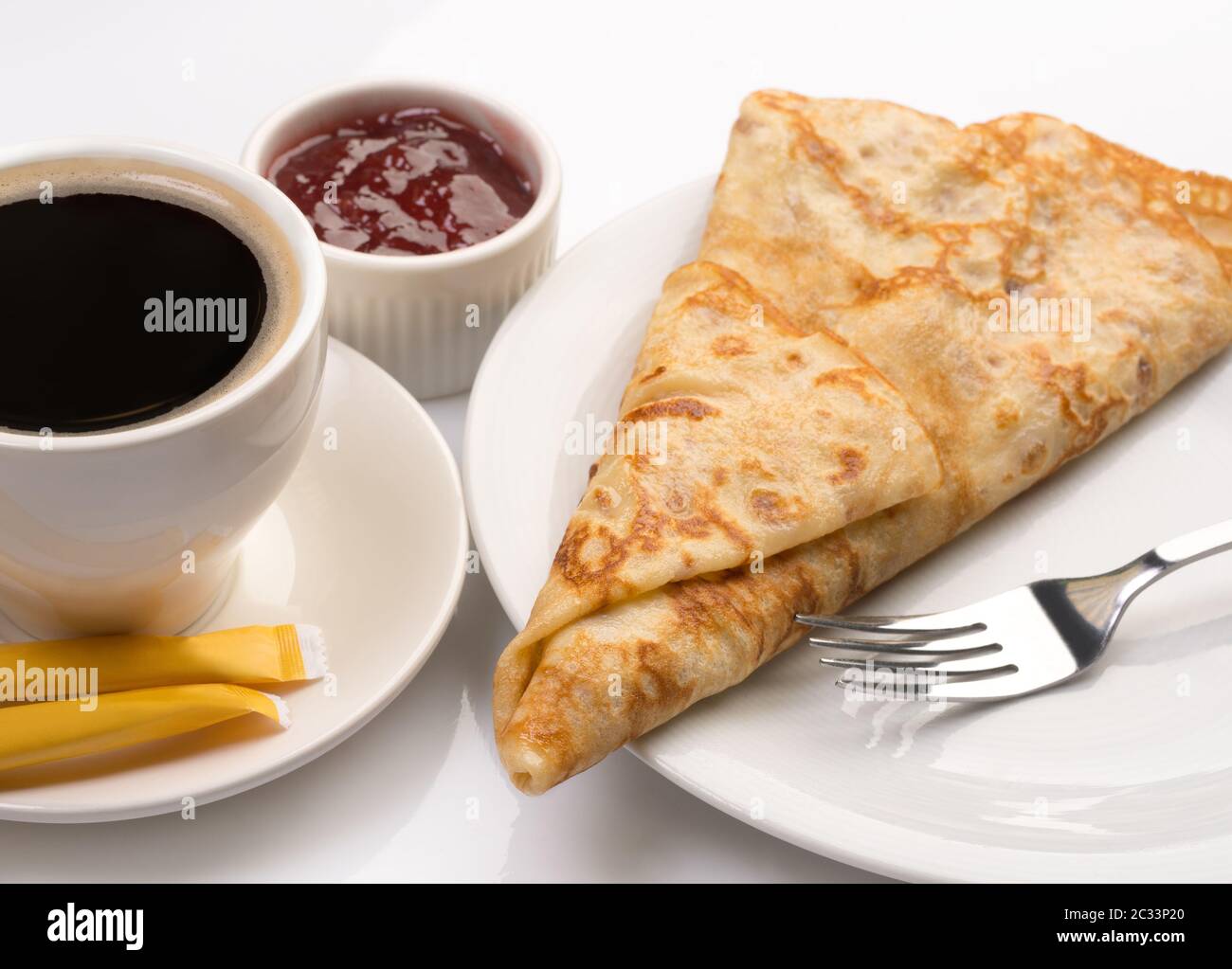 Frisches Dessertpfannkuchen und kräftiger Kaffee auf Weiß Stockfoto