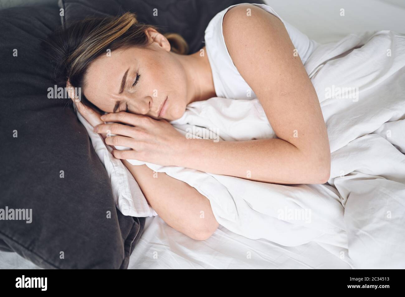 Depressive Frau gequält durch unruhigen Schlaf, sie ist erschöpft und leidet an Schlaflosigkeit, schlechten Träumen oder Alpträumen, psychischen Problemen Stockfoto