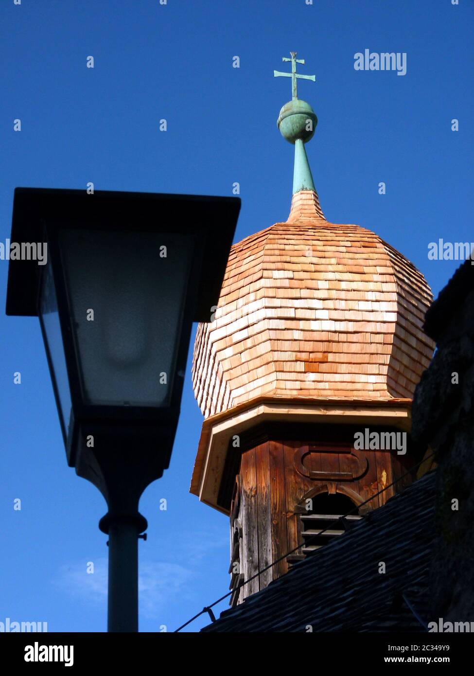 Zwiebelturm mit Kupferspitze einer mittelalterlichen Holzkirche vor blauem Himmel Stockfoto