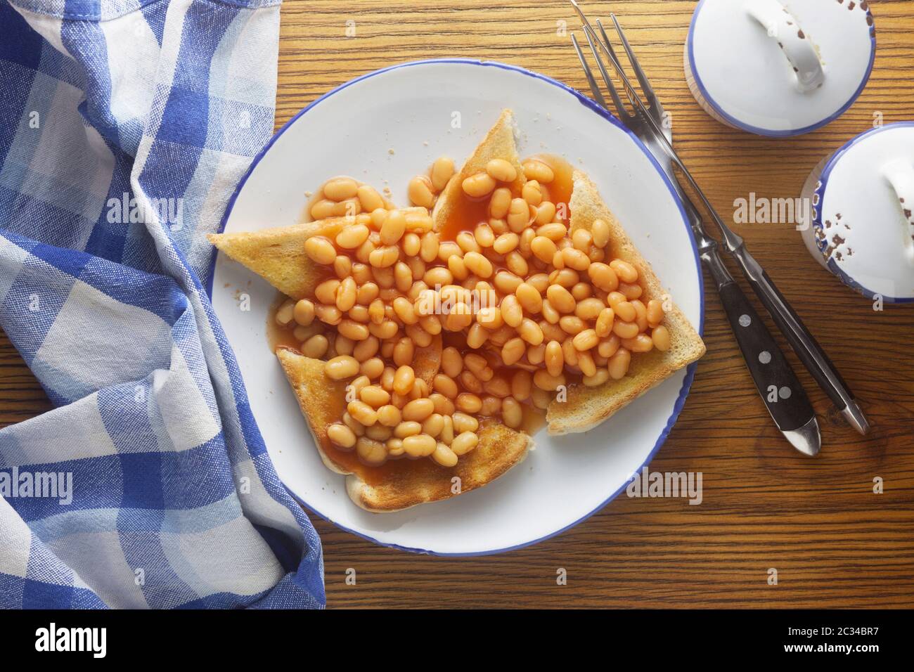 Gebackene Bohnen auf Toast auf einem hölzernen Hintergrund Stockfoto