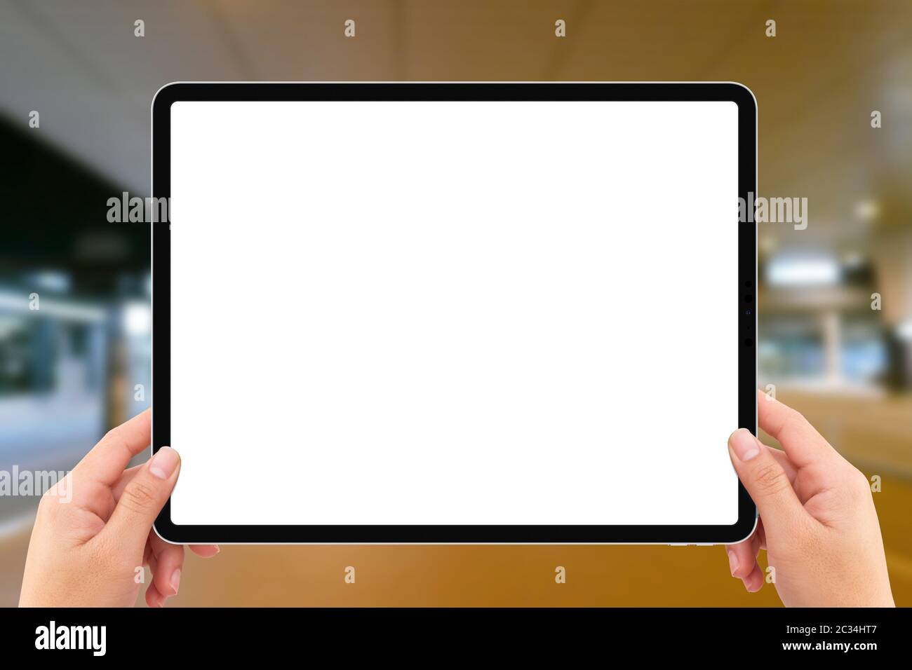 Die menschlichen zwei Hände halten weißen Bildschirm mockup Tablet-Computer in Flughafen-Terminal Verkehrsstation Stockfoto