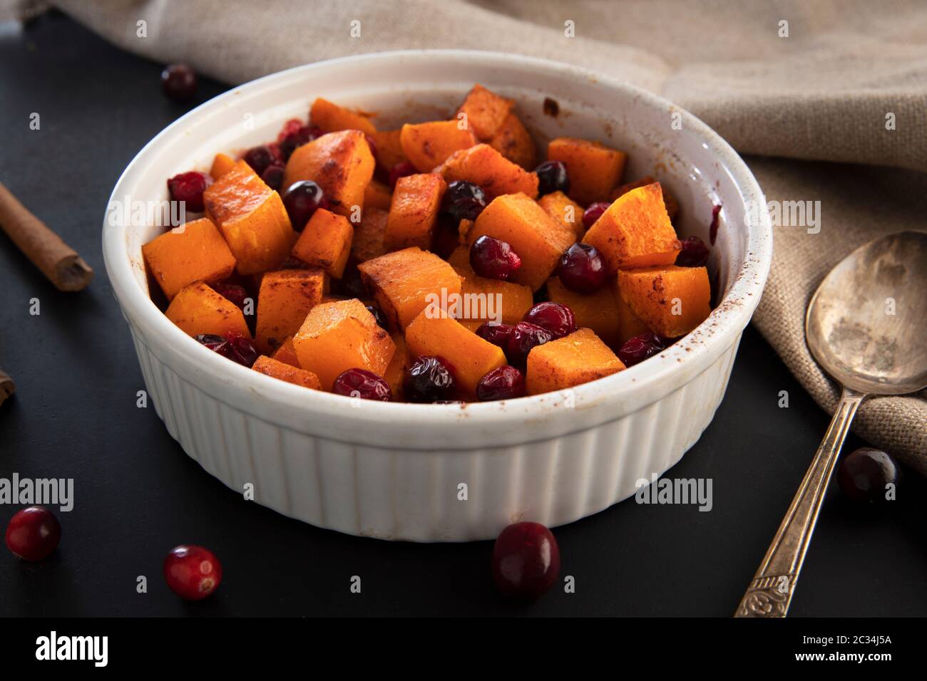 Gebackener butternut Kürbis und Preiselbeeren mit Honig und Zimt, gerade aus dem Ofen. Stockfoto