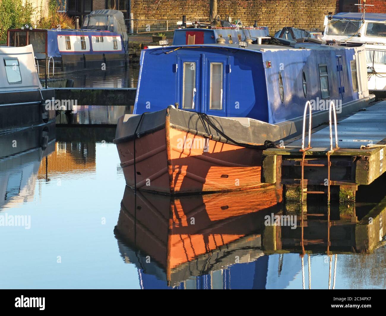 Alte schmale Boote, die in Hausboote umgewandelt wurden, vertäuten in der Marina am brighouse Basin in West yorkshire Stockfoto