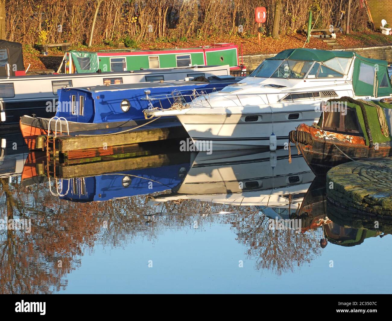 Alte schmale Boote, die in Hausboote umgewandelt wurden, vertäuten in der Marina am brighouse Basin in West yorkshire Stockfoto