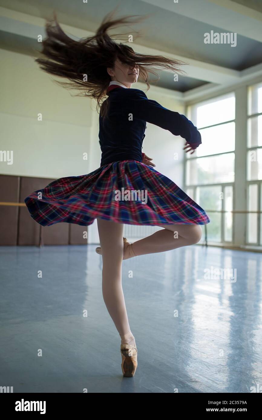 Langhaarige Ballerina dreht sich in der Tanz-Moves auf einem Bein zu sta Stockfoto