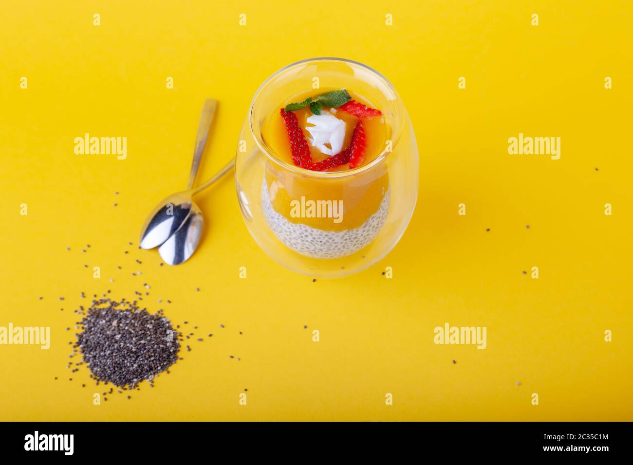 Mango-Pudding mit chia-Samen in Glas auf gelbem Hintergrund Stockfoto