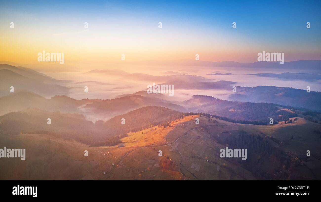 Antenne Panorama der wunderschönen Herbst Berge. Sonnenaufgang über Berg nebligen Tal. Misty woodland am Morgen. Karpaten, Ukraine Stockfoto