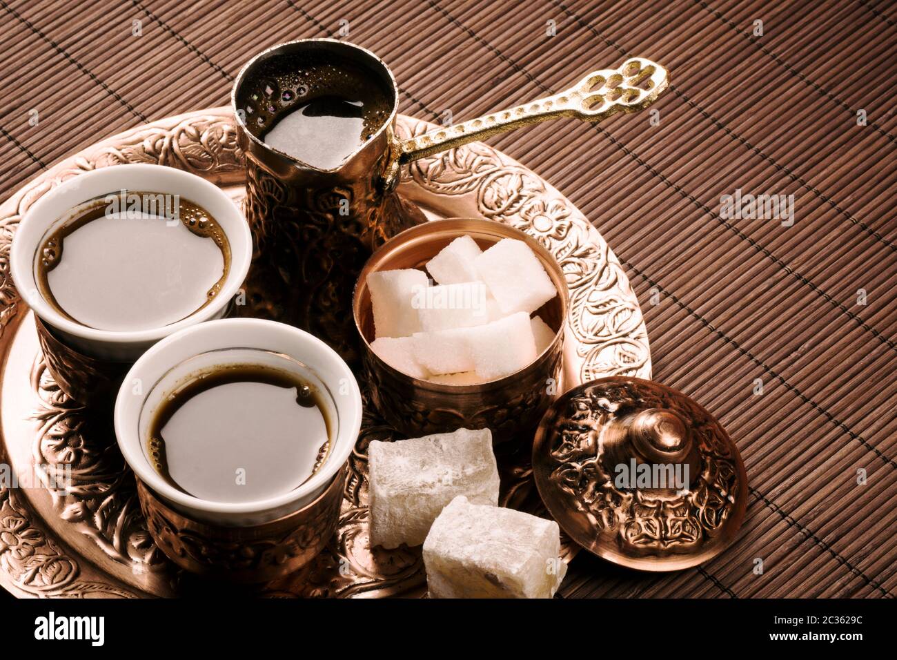 Traditionelles türkisches Kaffeeset mit zwei Kaffeetassen, Zucker und türkischem Genuss auf braunem Hintergrund. Stockfoto