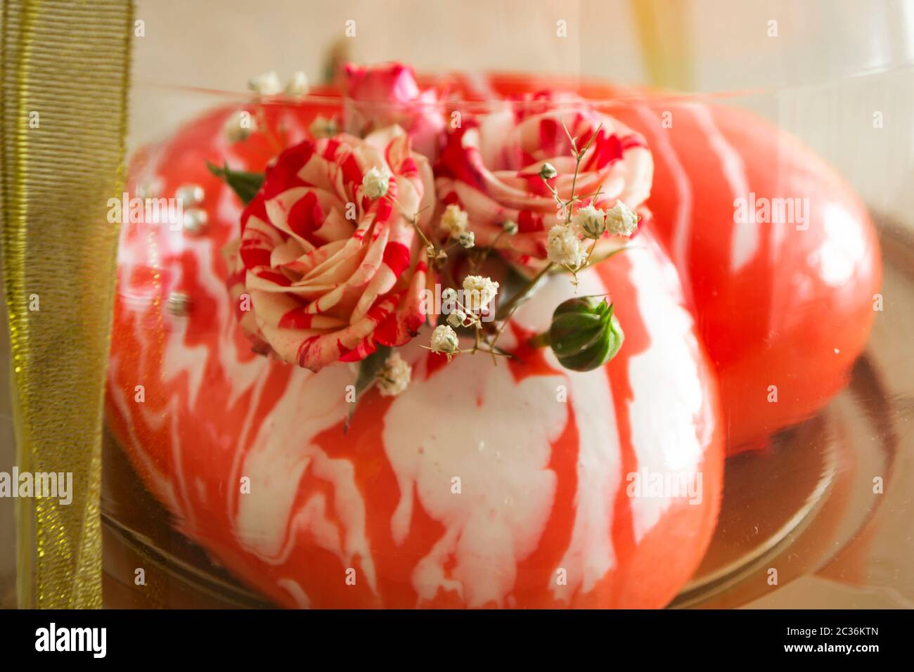 Mousse Kuchen in Form von Herz mit kleinen Rosen, Kuchen in transparenter Box Stockfoto