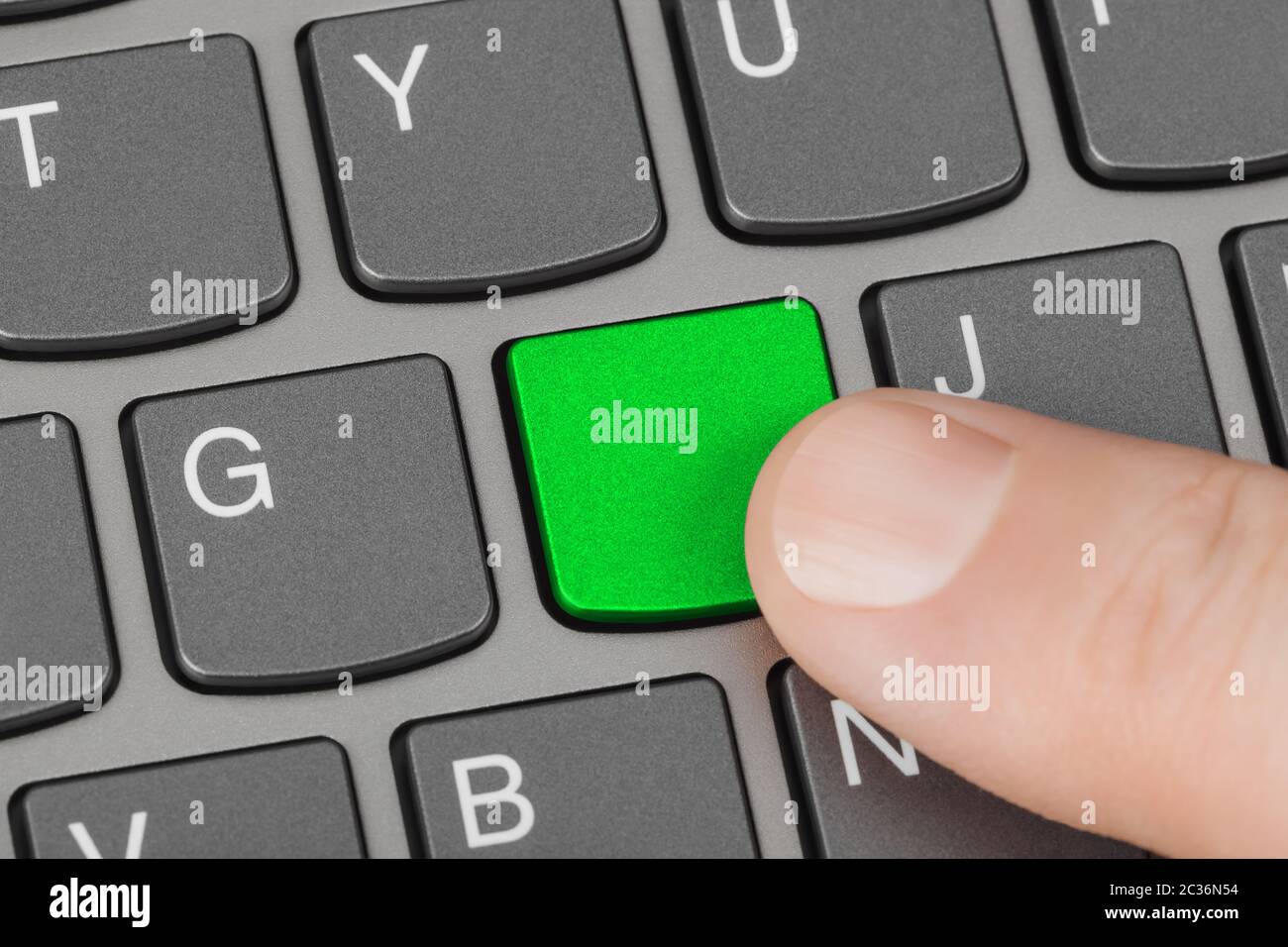 Computer-Notebook-Tastatur mit grünen Schlüsselrohling Stockfoto