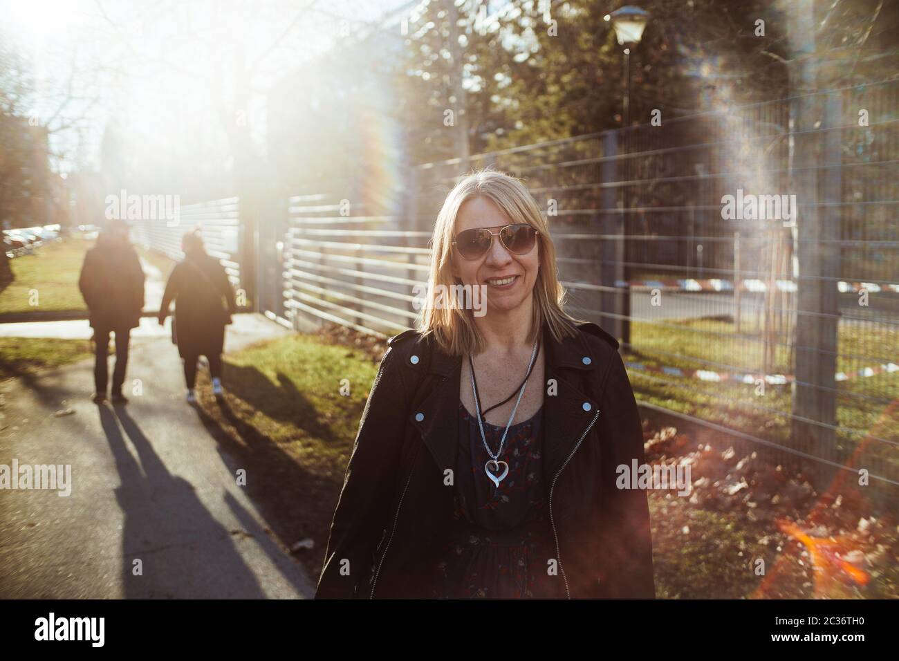 Blonde glückliche Frau auf einem Spaziergang zusammen mit ihren Freunden. Authentische Menschen Porträt Stockfoto