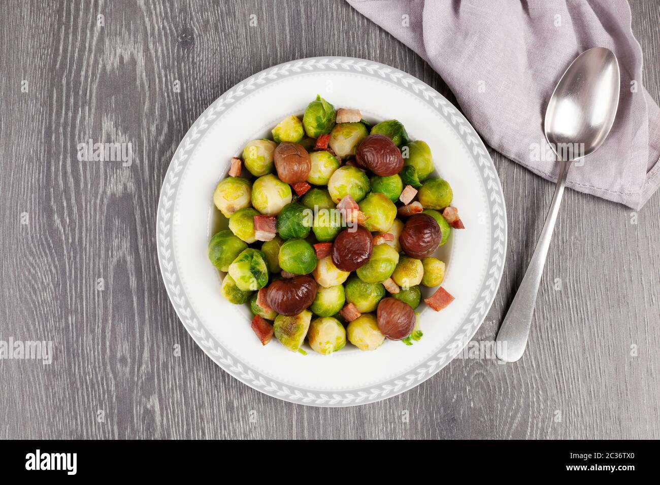 Gerösteter Rosenkohl mit Speck und Kastanien von oben. Stockfoto