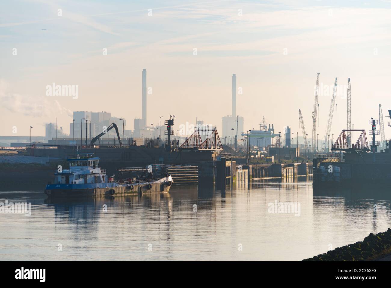 Auf dem Weg zum Hafen von Amsterdam passiert das Schleppboot eine offene Schleusentür in Ijmuiden, Niederlande Stockfoto