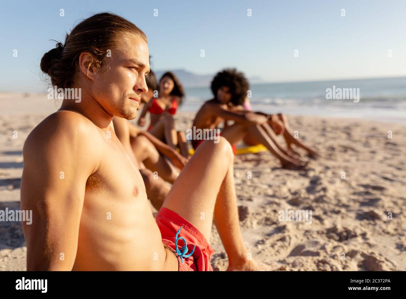 Gemischte Rennfreunde liegen am Strand Stockfoto