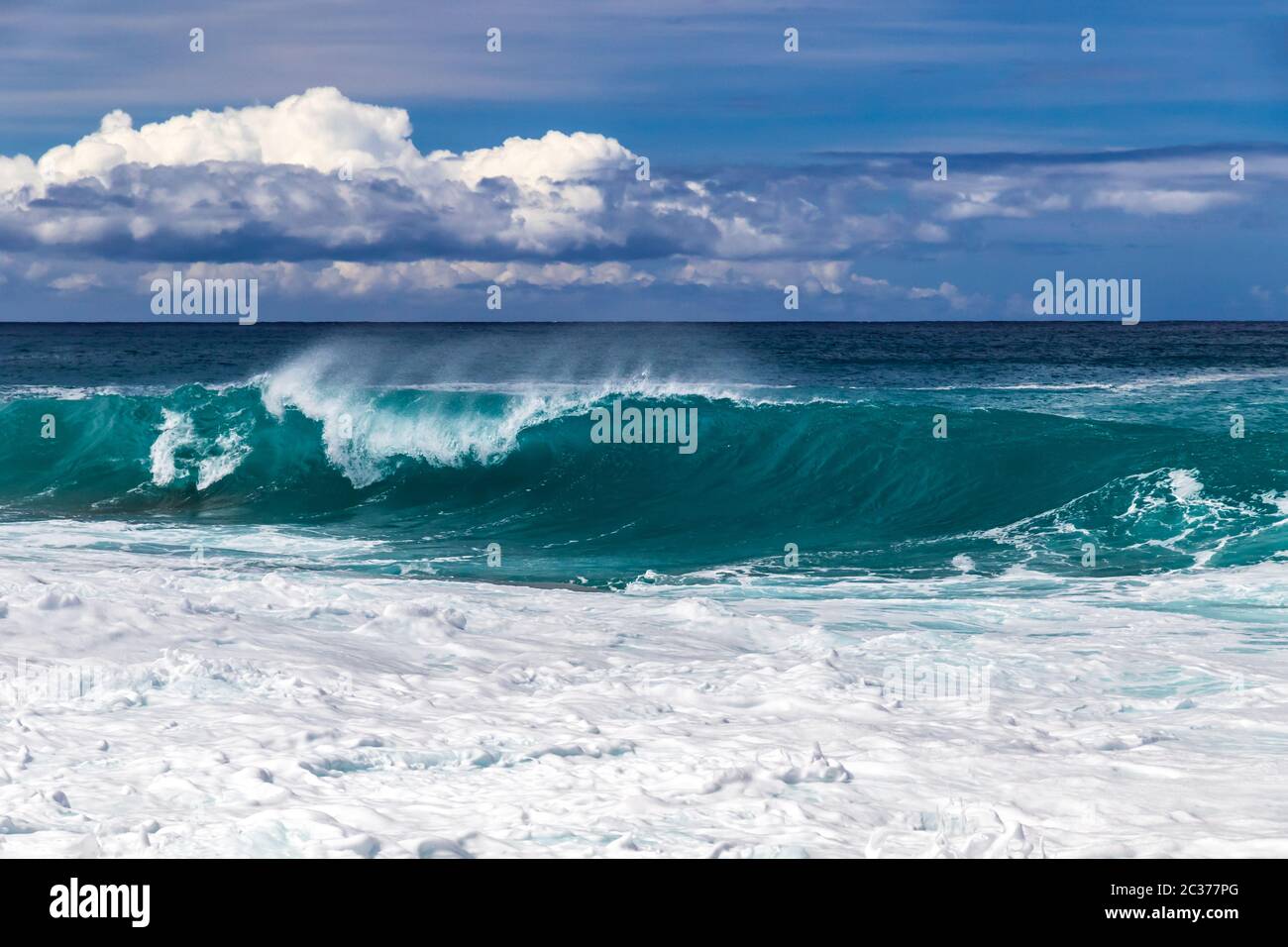 Wellenbrecher an der westlichen Kona Küste von Hawaiis Big Island. Spray und Schaum im Vordergrund. Pazifik, Himmel mit Wolken dahinter. Stockfoto