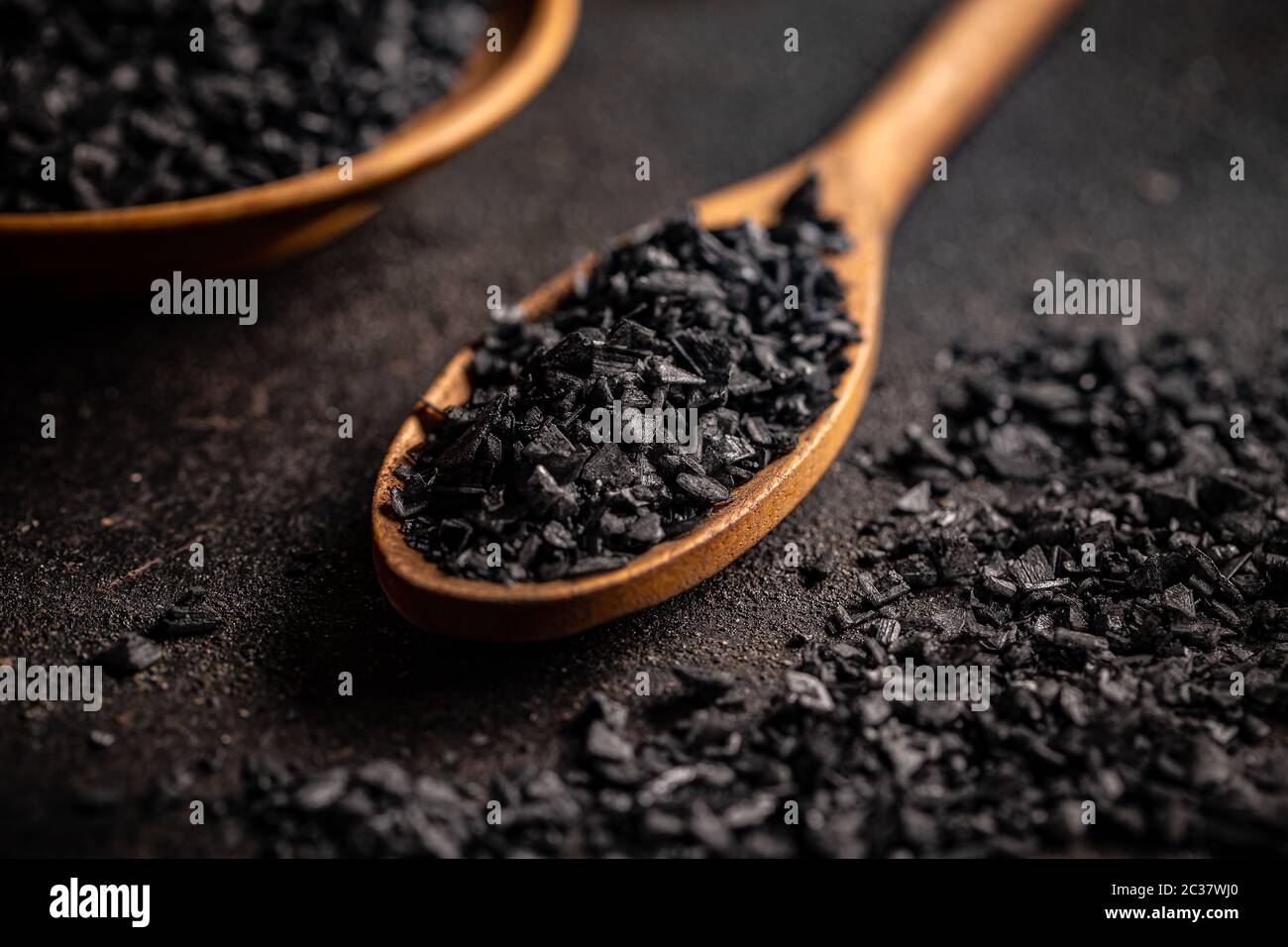 Schwarzes Gourmetsalz aus dem Himalaya im Löffel auf dunklem Hintergrund Stockfoto
