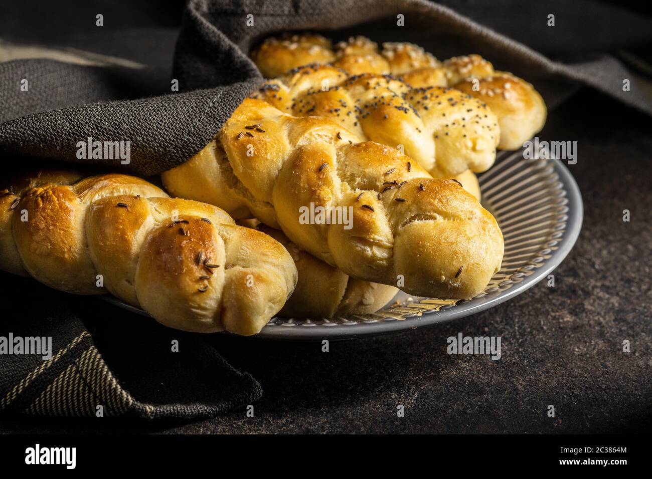 Leckere Flechtbrötchen auf schwarzem Küchentisch. Stockfoto