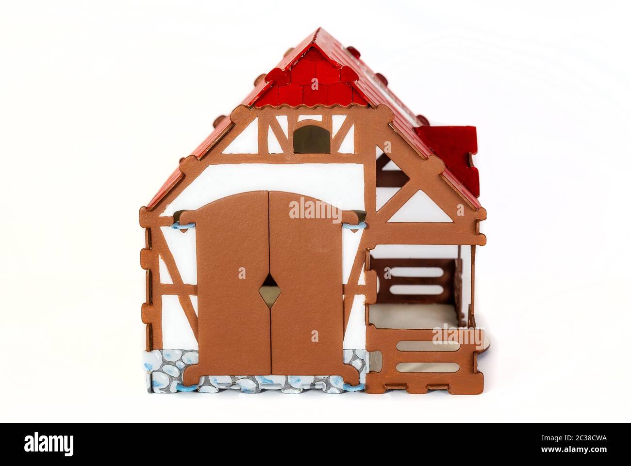 Spielzeughaus aus ländlicher Pappe, Vorderansicht, mit einem roten Dach auf hellem Hintergrund Stockfoto