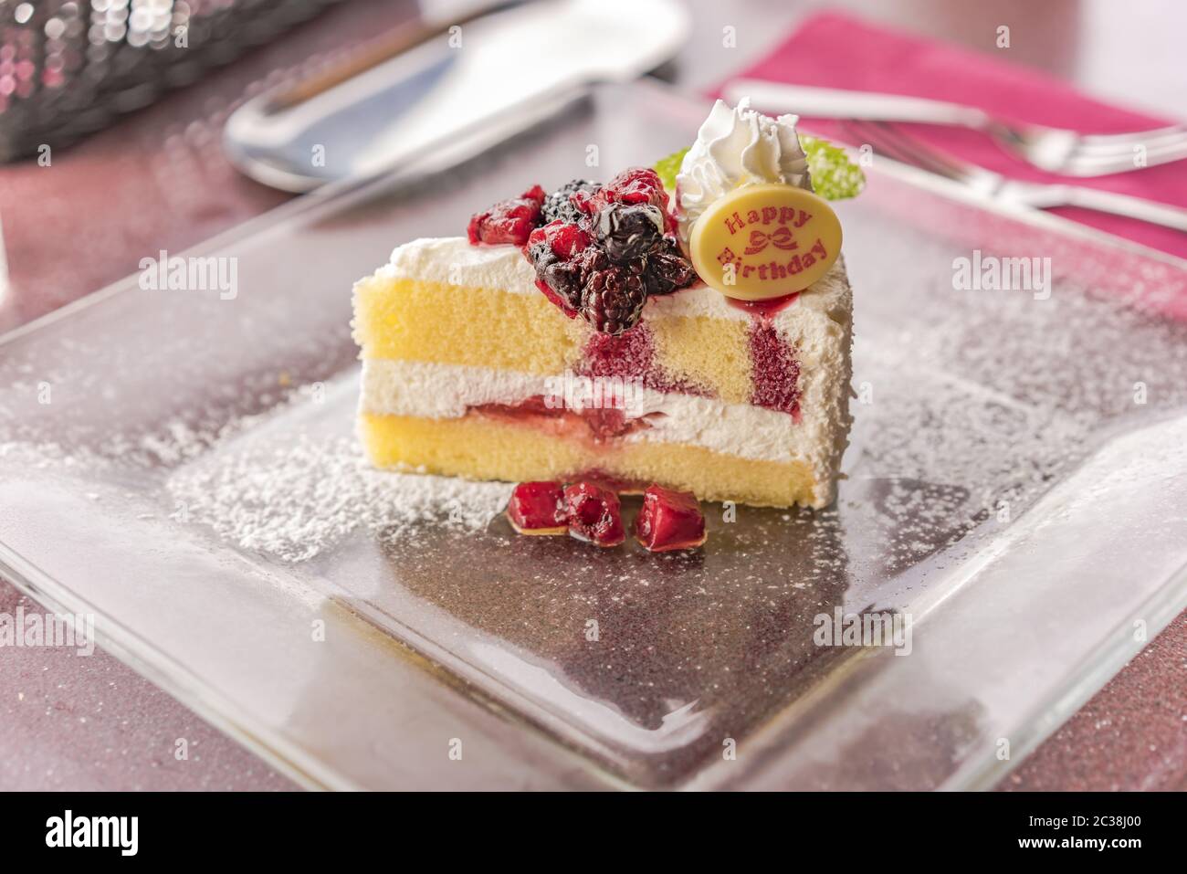 Serviergröße slServiereis von hausgemachten Erdbeer-Obst-Geburtstagstorte mit weißer Sahne und Minze Blatt. Stockfoto