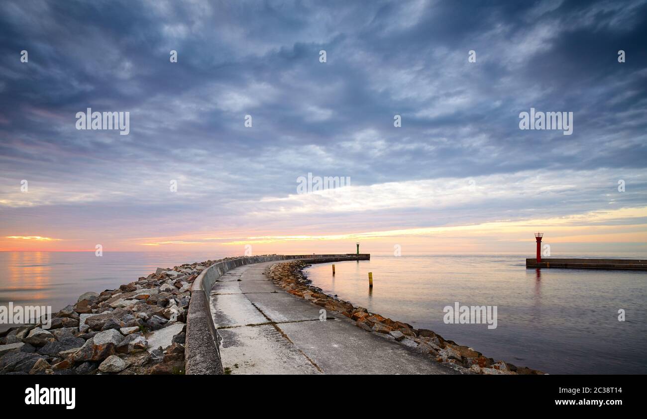 Panoramablick auf felsigen Pier am Eingang zum Hafen Mrzezyno bei Sonnenuntergang, Polen. Stockfoto
