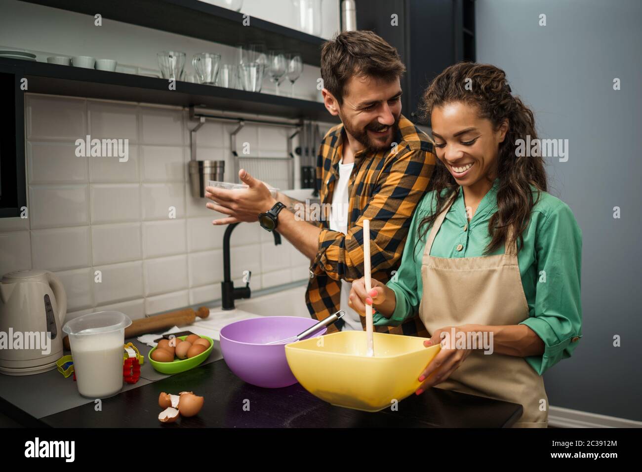Happy multiethnischen Paar Kochen in ihrer Küche. Sie machen Cookies. Stockfoto