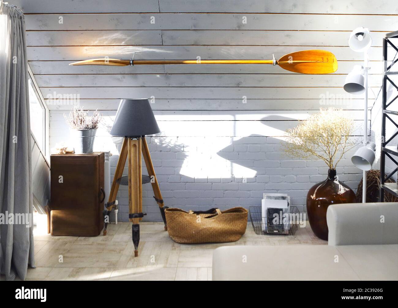 Helles Wohnzimmer mit Lampen und Paddel an der Wand Stockfoto