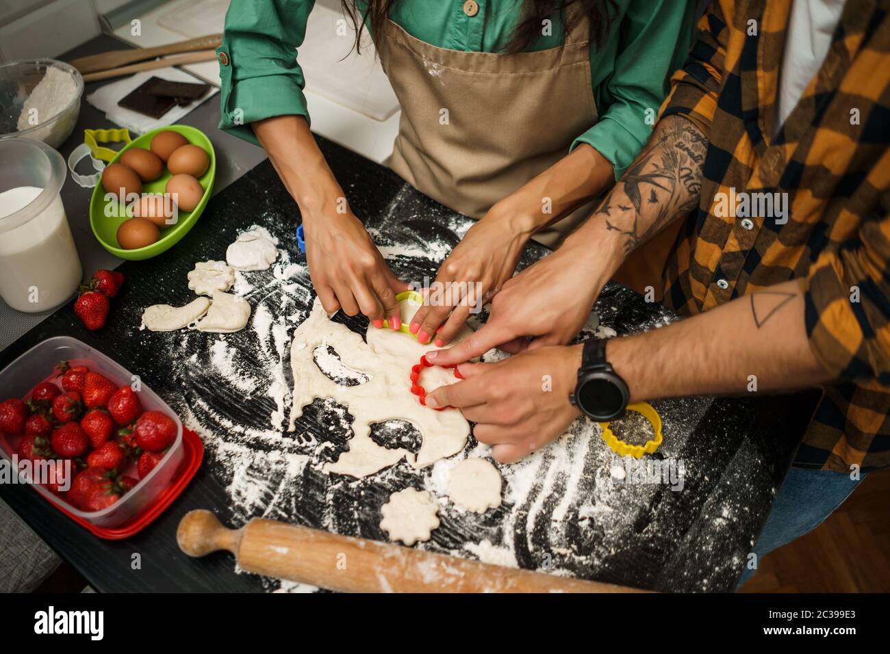 Nahaufnahme eines multiethnischen Paares, das in seiner Küche Kekse macht. Stockfoto