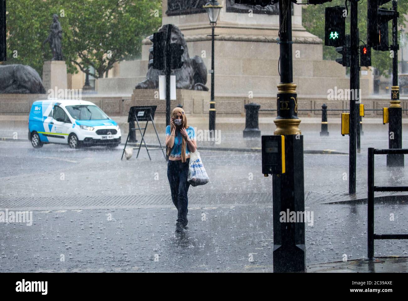 Bild zeigt: Sturmflut auf dem Traflagar Square führte zu Überschwemmungen viele im Regen gefangen, während andere geschützt Bild von Gavin Rodgers/ Pixel8000 Stockfoto