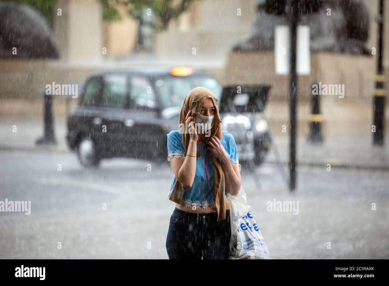Bild zeigt: Sturmflut auf dem Traflagar Square führte zu Überschwemmungen viele im Regen gefangen, während andere geschützt Bild von Gavin Rodgers/ Pixel8000 Stockfoto