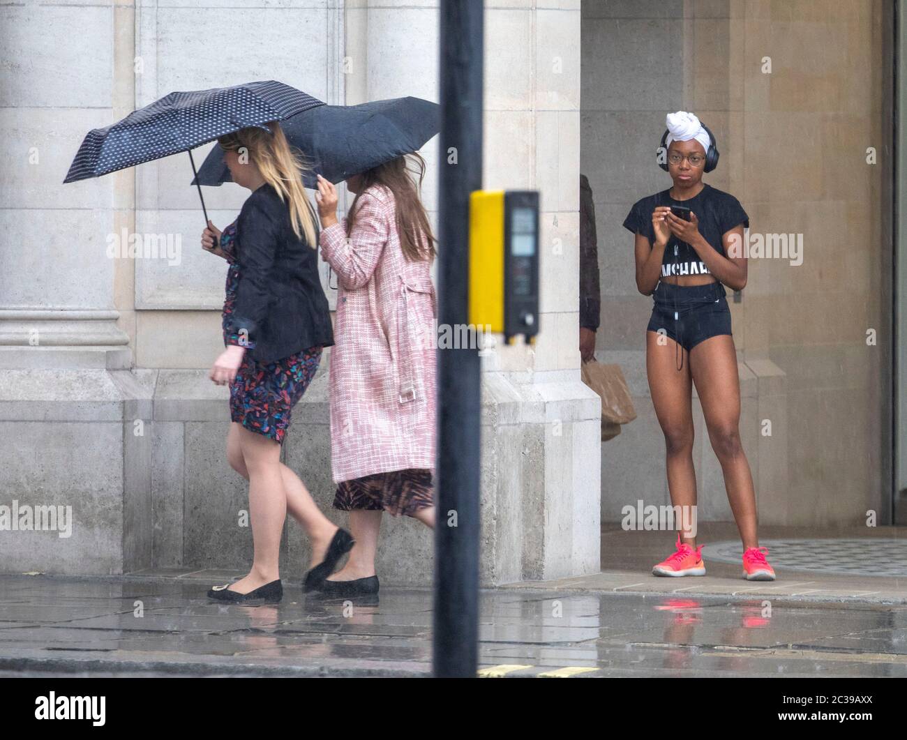 Bild zeigt: Sturmflut auf dem Traflagar Square führte zu Überschwemmungen viele im Regen gefangen, während andere geschützt Bild von Gavin Rodgers/ Pixel8000 Stockfoto