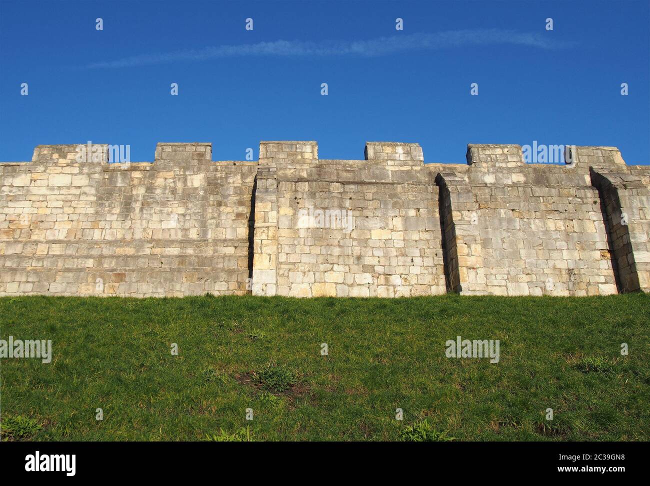 Ein Blick auf die alten mittelalterlichen Stadtmauern von york mit Gras bedeckt Böschung und blauen Himmel Stockfoto