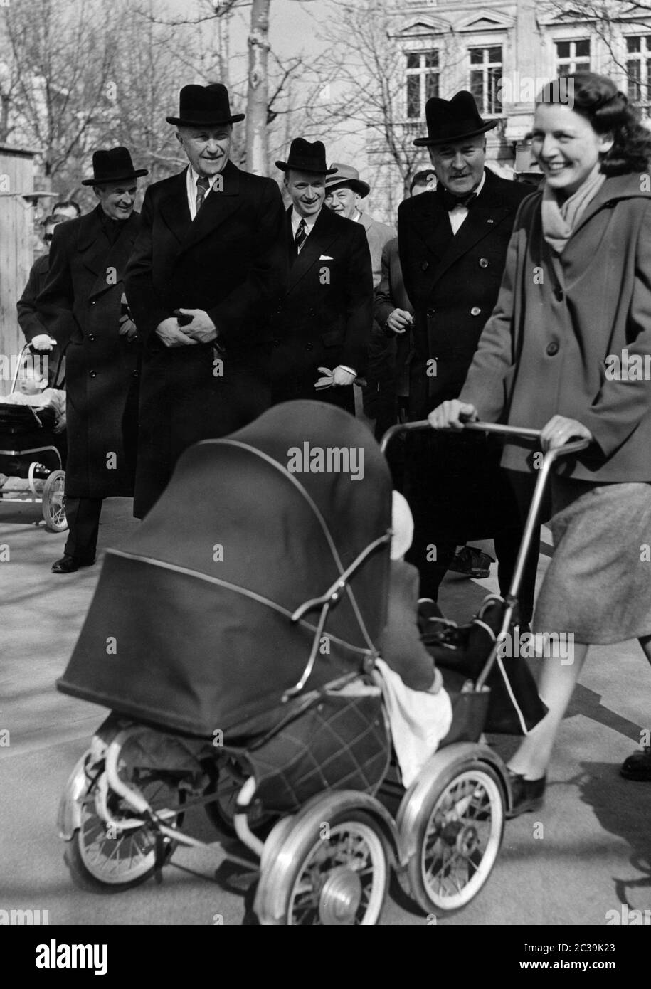 Bundeskanzler Konrad Adenauer (links) und der französische Diplomat Andre Francois-Poncet (links) gehen auf den Champs-Elysees. Im Vordergrund ist ein Passant mit einem Kinderwagen. Stockfoto