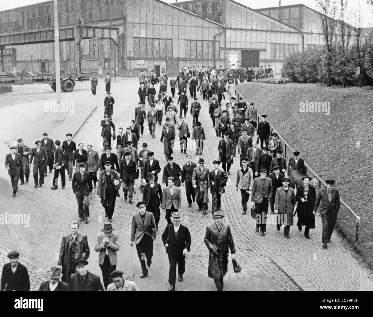 Industriearbeiter verlassen das Fabrikgelände. Stockfoto