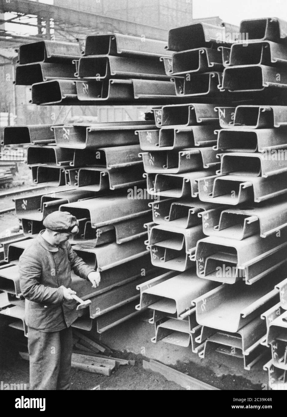 Arbeiter, die in einer Metallfabrik an Stahlträgern arbeiten. Stockfoto