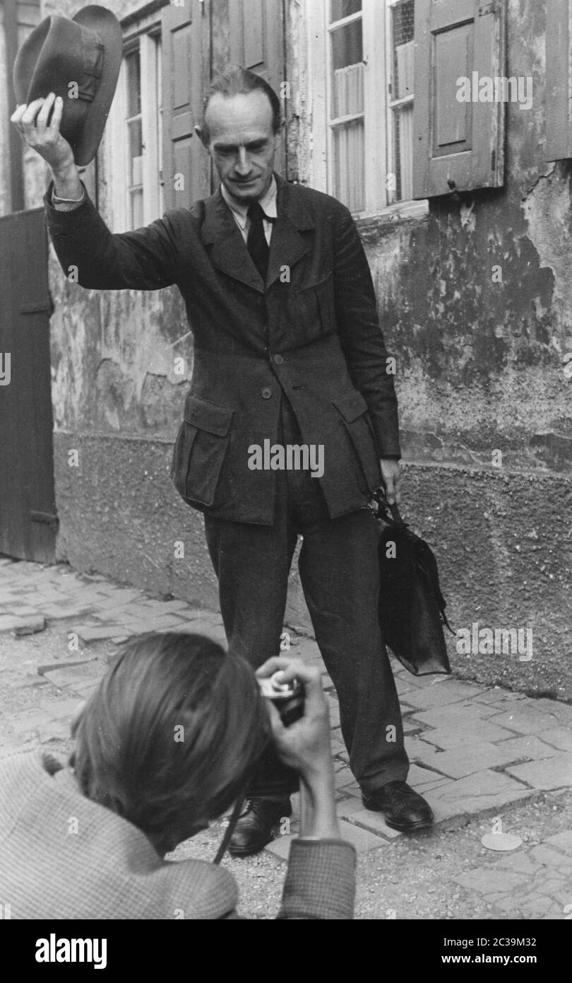 Ein Mann zieht sich zu einem Fotografen auf der Straße. Das Bild stammt aus einem Bericht mit dem Titel 'wie geht es Ihnen Herr Hansen?' ('wie geht es Ihnen, Herr Hansen?') Undatierte Aufnahme. Stockfoto