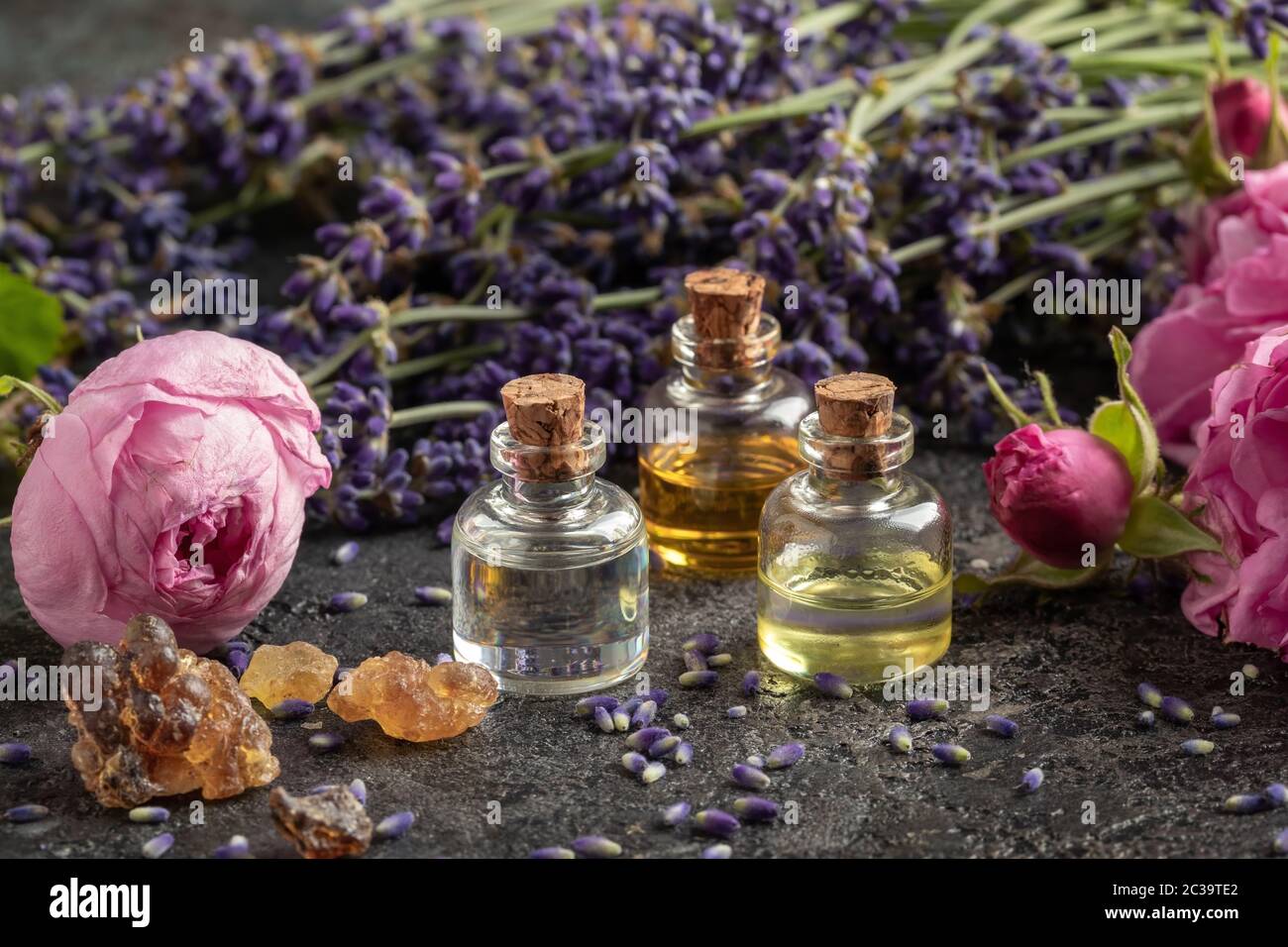 Drei Flaschen ätherisches Öl mit Weihrauchharz, Kohlrosenblüten und Lavendel Stockfoto