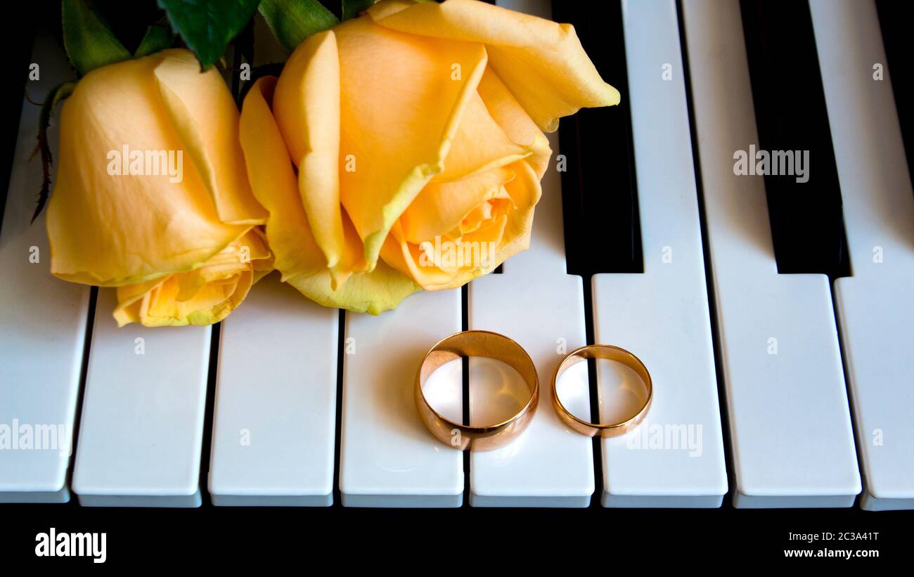 Als Geschenk an die geliebte Frau, gelbe Rosen liegen auf dem Piano mit Verlobungsring auf der Tag der Hochzeit, Verlobung, den internationalen Tag der Frau oder weddin Stockfoto
