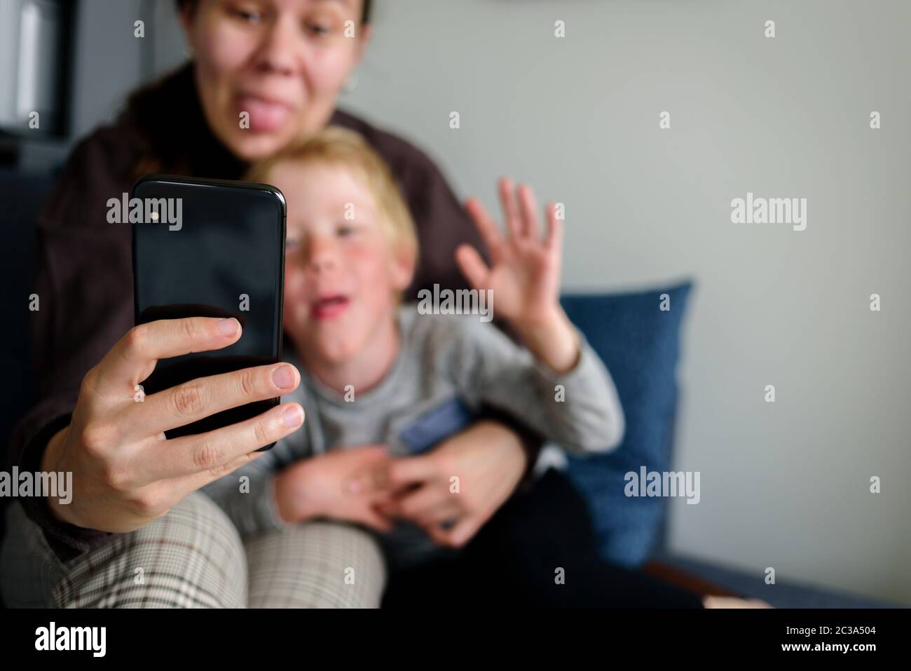 Mutter und Kind, die Videoanruf haben, zusammen lächeln, Sprache zeigen Stockfoto