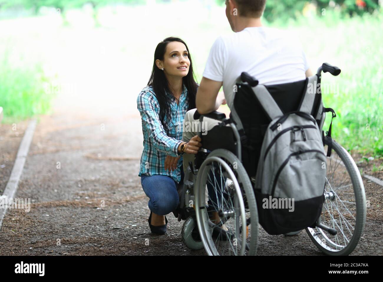 Behindertes Paar in der Liebe auf einem Spaziergang im Park Porträt. Frau schaut ihren Mann in Liebe mit Augen an Stockfoto