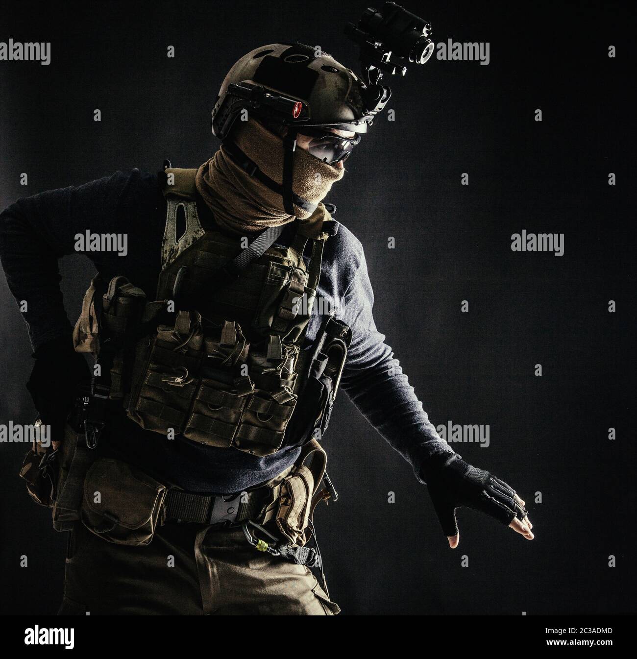 Spezialoperationen Kämpfer im Helm mit Nachtsicht, Wärmebildgerät, Ladungsträger vorsichtig bewegen mit Vorsicht in der Dunkelheit, Hand o halten Stockfoto
