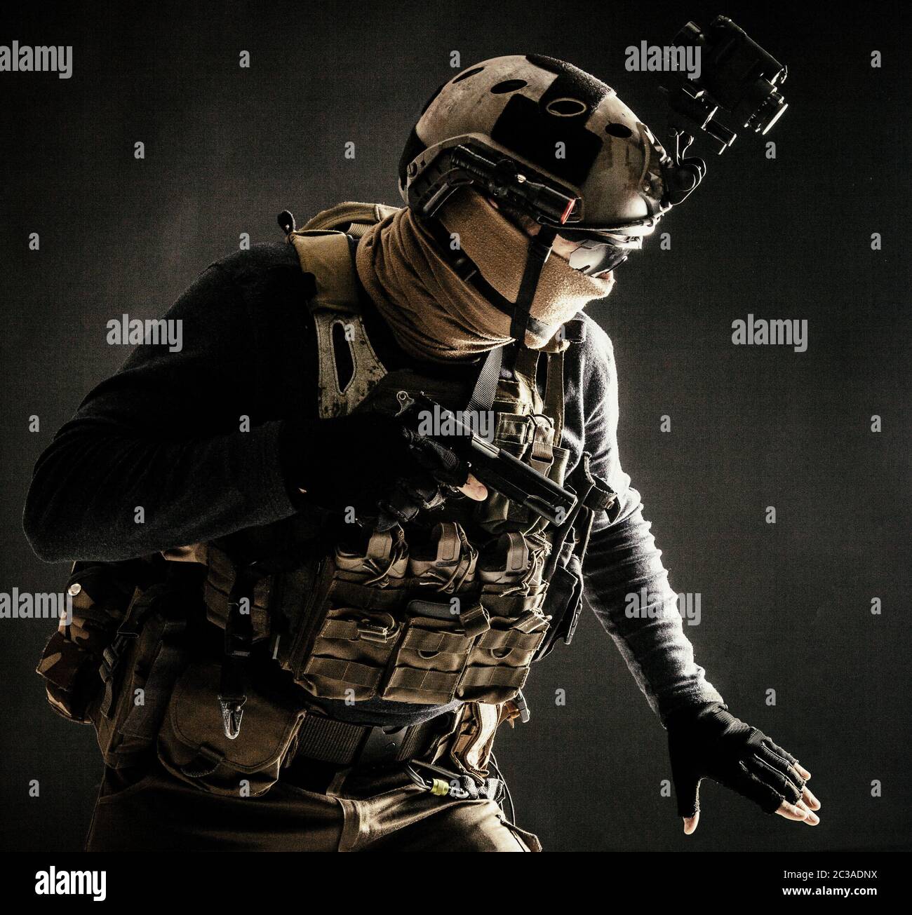 Spezialoperationen Kämpfer im Helm mit Nachtsicht, Wärmebildgerät, Ladungsträger vorsichtig bewegen mit Vorsicht in der Dunkelheit, Hand o halten Stockfoto