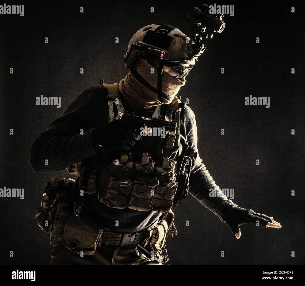 Spezialoperationen Kämpfer im Helm mit Nachtsicht, Wärmebildgerät, Ladungsträger vorsichtig bewegen mit Vorsicht in der Dunkelheit, Hand o halten Stockfoto