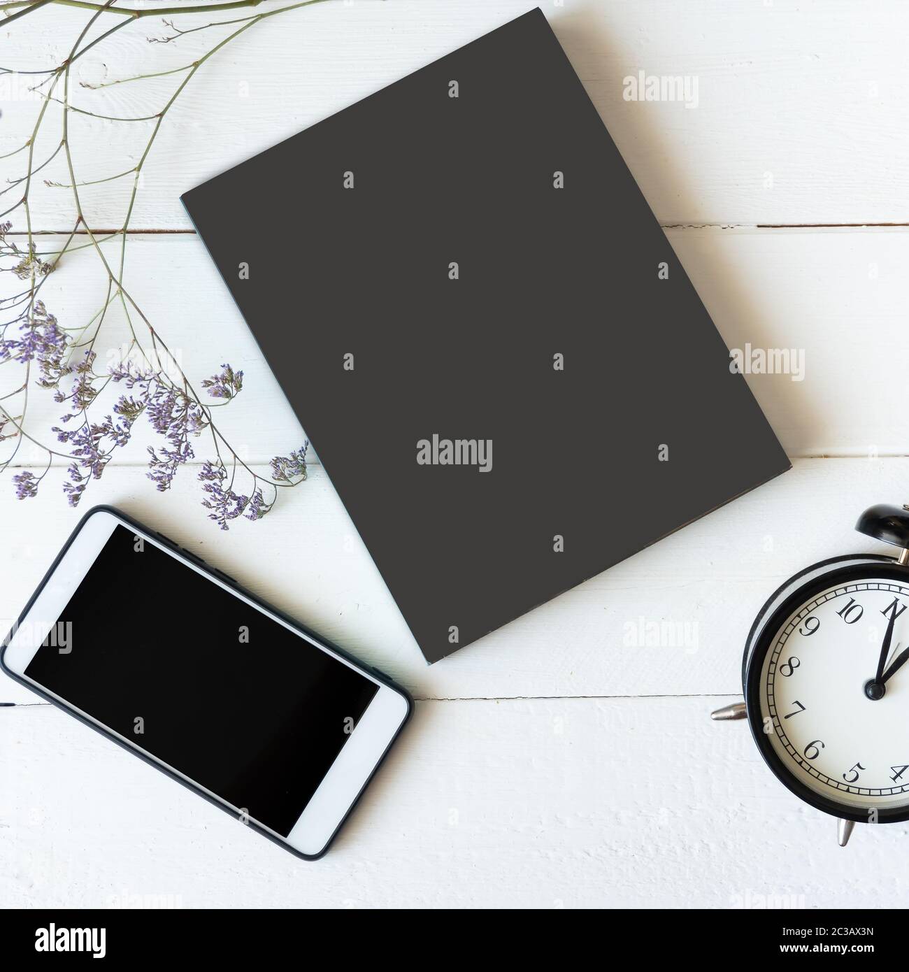Mockup Flat Lay Komposition mit Buch, Smartphone, Uhr auf weißem Tisch Stockfoto