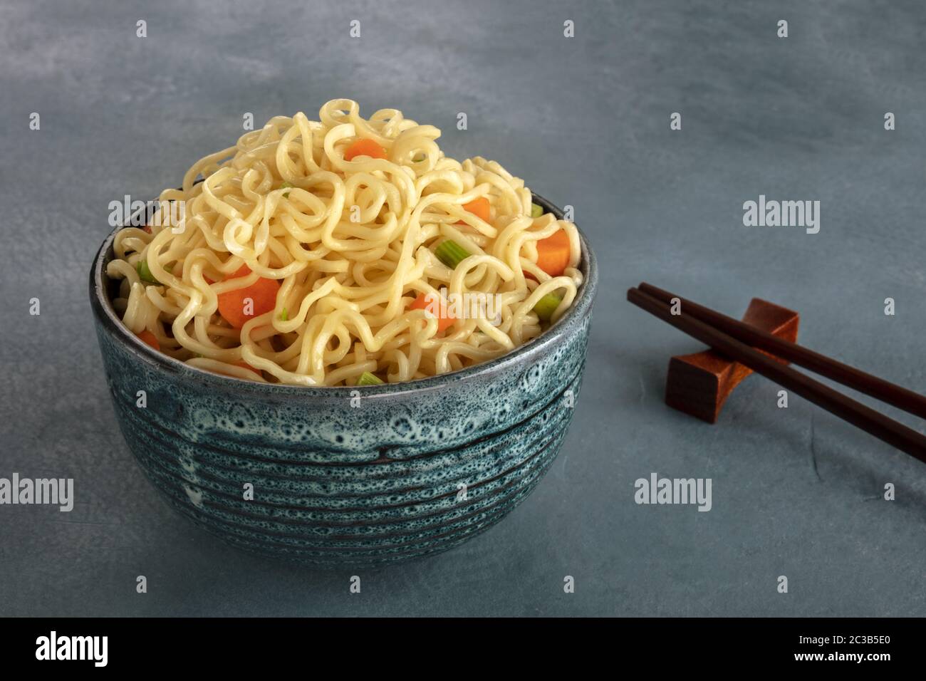 Nudelschüssel mit Karotten und Hengsten, mit Essstäbchen Stockfoto