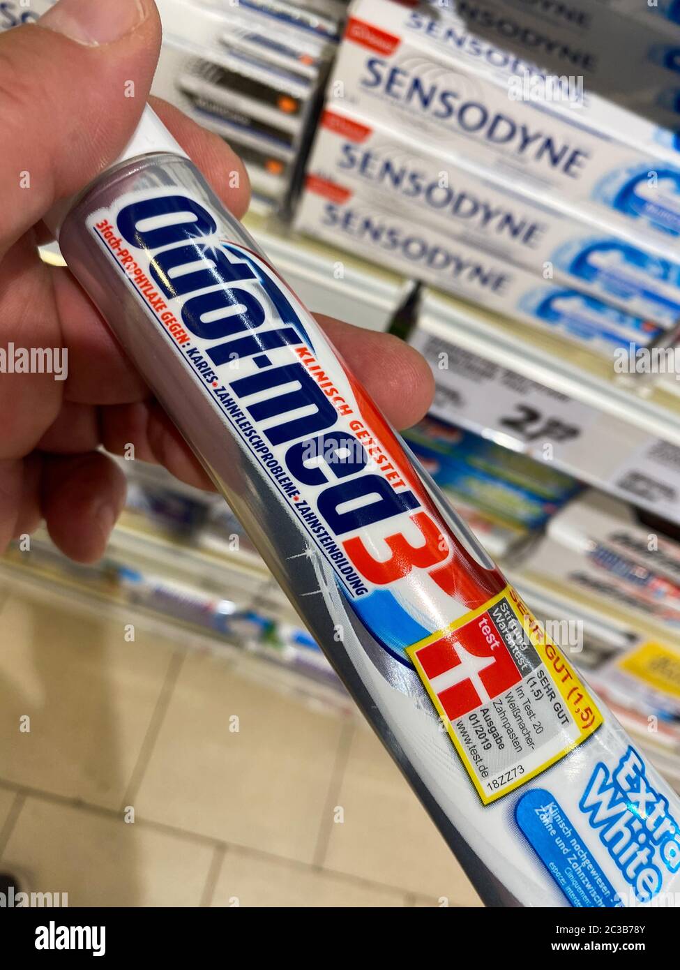 Tönisvorst, Deutschland - Juni 18. 2020: Ansicht auf isolierte Tube Odol-med 3 Zahnpasta von Hand vor dem Regal halten (Fokus auf Tube) Stockfoto