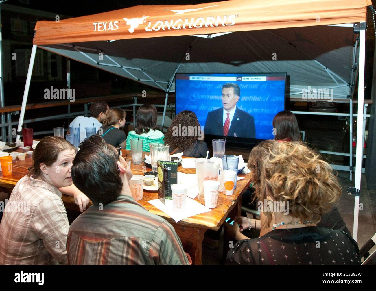 Austin, Texas, USA, 3. Oktober 2012: Große Gruppe besucht eine Beobachtungsparty für die erste Mitt Romney/Barack Obama Präsidentschaftsdebatte im Fernsehen aus einem Restaurant in der Nähe des Campus der University of Teas. ©MKC / Daemmrich Photos Stockfoto