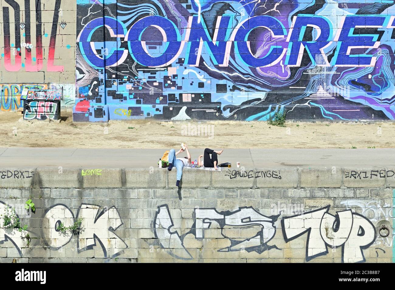 Wien, Österreich. Zwei Personen genießen die Frühlingssonne in Wien am Donaukanal. Stockfoto