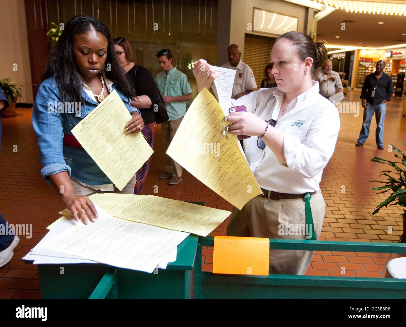 6. November 2012 Austin, Texas: Die Wähler sehen sich Beispielwahlzettel an, während sie darauf warten, ihre Stimme an einem Wahllokal in Travis County abzugeben. ©MKC / Daemmrich Photos Stockfoto