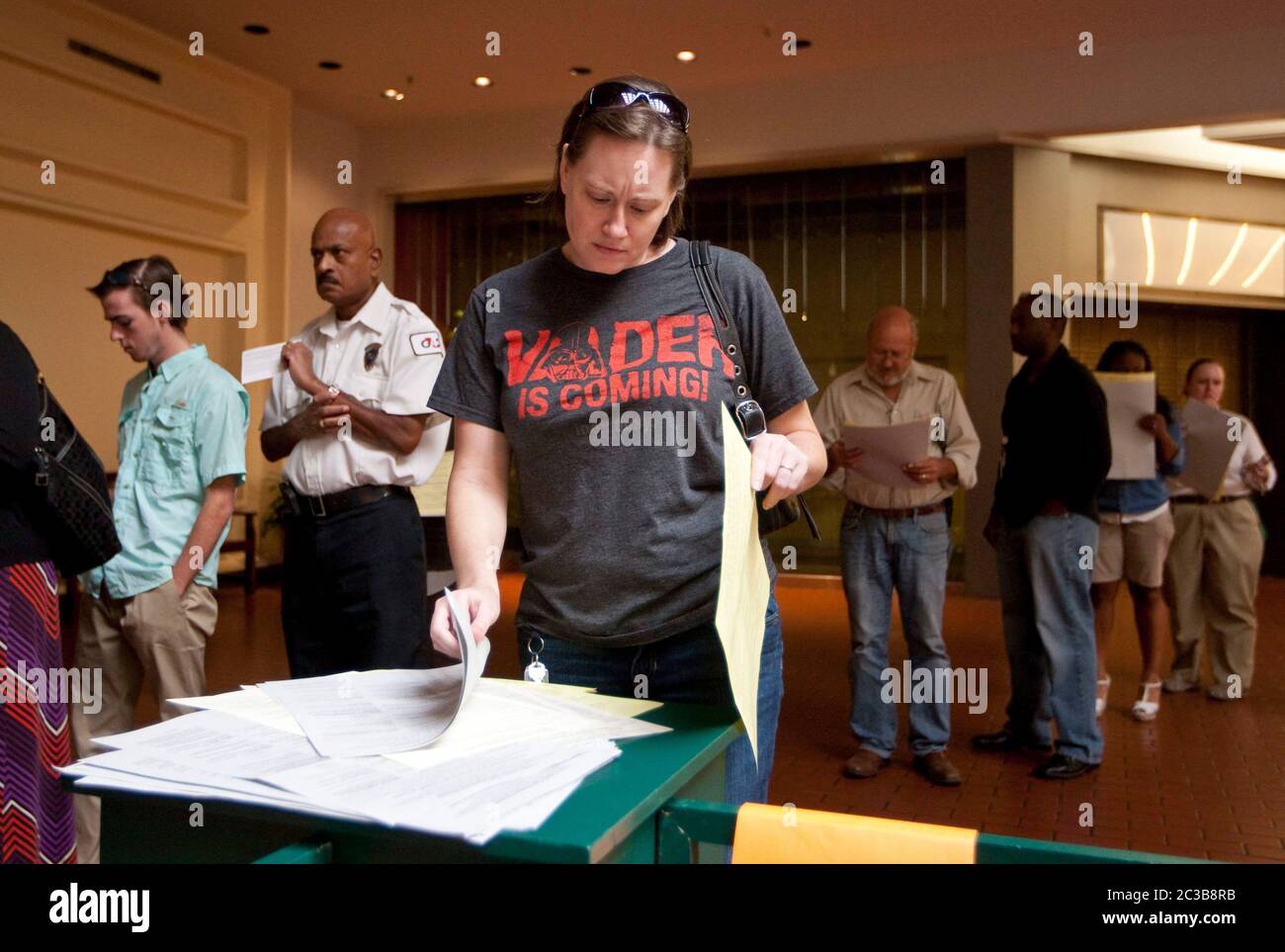 6. November 2012 Austin, Texas: Die Wähler sehen sich Beispielwahlzettel an, während sie darauf warten, ihre Stimme an einem Wahllokal in Travis County abzugeben. ©MKC / Daemmrich Photos Stockfoto